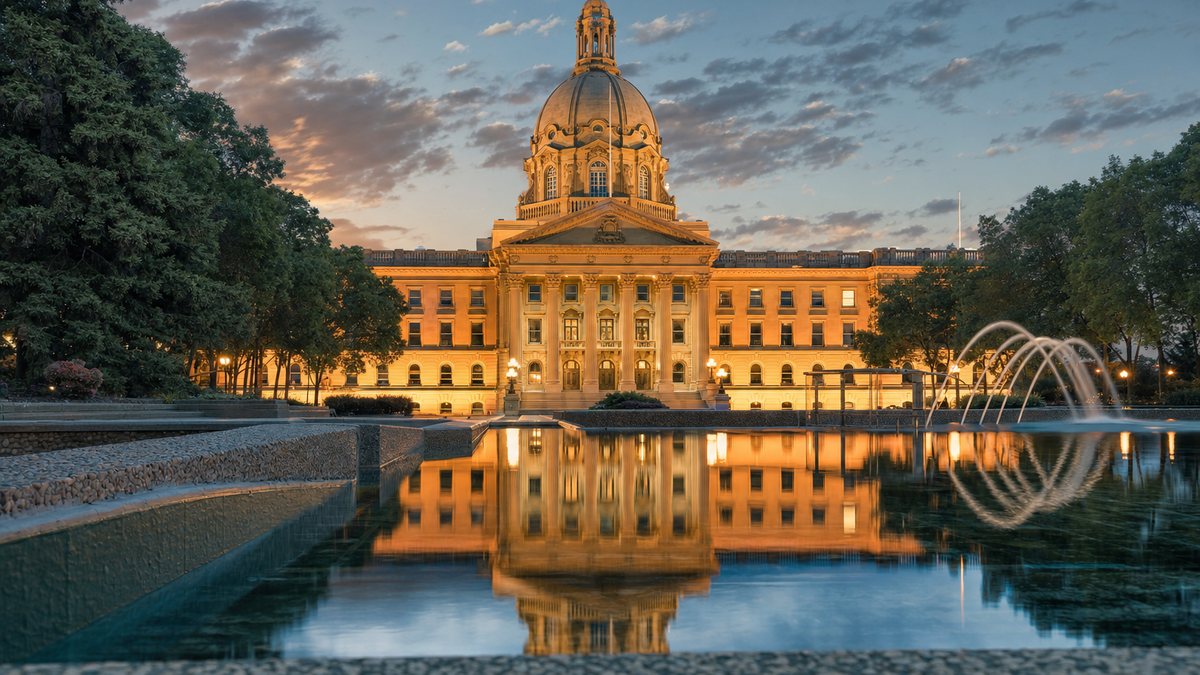 Alberta Legislature building reflected in water at dusk, illustrating Alberta's July 2026 online casino launch